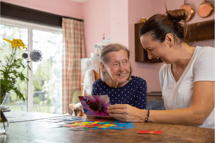 A carer laughs with an elderly woman